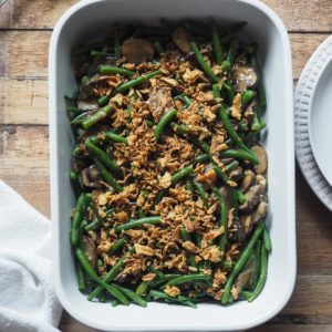 The green bean casserole you'll need in summer! Fresh green beans to make the most of summer produce, dairy-free mushroom sauce, yet creamy and delicious, and a crispy onion top, all made under 20min. Guaranteed side dish hit! An oven safe dish with the green bean and mushroom sauce mixture can be seen in the shot, topped with the crispy fried onion.
