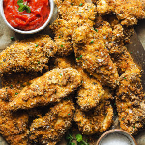 These Baked Crispy Cornflake Chicken Tenders are the perfect weeknight (or weekday) meal. They just need a handful of minutes to be prepared and are all cooked in one go.The chicken is coated in seasoned crushed cornflakes and baked to crispy perfection. Cooking them in the oven makes them lighter and healthier than their deep fried counter part, but they are just as delicious. It's so easy! | Paula's Apron Recipe